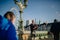 Bagpiper playing Scottish music while tourist walk by Westminster Bridge, with the London Eye in the background.