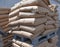 Bags of cement are stacked on a pallet in the store\\\'s warehouse.