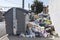 Bags full of trash surrounding dumpsters