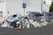 Bags full of trash surrounding dumpsters, angle view