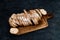 baguette bread sliced in cutting broad on wood background.