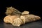 Baguette and ciabatta, bread slices on dark wooden table. Wheat and fresh mixed breads on black background.