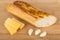 Baguette, garlic and pieces of cheese on table