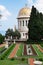 Bahai temple with golden dome, trees and fir-trees near it