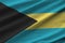 Bahamas flag with big folds waving close up under the studio light indoors. The official symbols and colors in banner