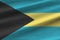 Bahamas flag with big folds waving close up under the studio light indoors. The official symbols and colors in banner