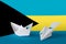 Bahamas flag depicted on paper origami airplane and boat. Handmade arts concept