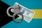 Bahamas flag with handcuffs and a bundle of dollars. Currency corruption in the country. Financial crimes