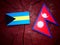 Bahamian flag with Nepali flag on a tree stump isolated