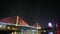 The Bai Chay Bridge in Ha Long, Vietnam lit up with colorful lighting at night.