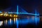 Bai chay bridge in halong bay Vietnam lit up with blue lighting reflecting off water