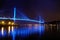 Bai chay bridge in halong bay Vietnam lit up with blue lighting reflecting off water