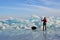 Baikal lake, Russia, March, 01, 2017. Traveler with a sledge-drag going in front of the ice ridges near the village of Bolshie Kot