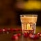 Baileys shot with grenadine seeds on wooden table