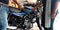 Bajaj automobile staff hand touching bike petrol tank at showroom in India