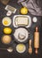 Bake ingredients and tools for lemon cookie or cake dough making on dark background, top view