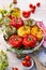 Baked bell peppers stuffed. Mushrooms, rice, cheese and herbs stuffed peppers in a baking dish on a white wooden table.