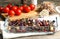 Baked black carrot with pomegranate seeds and nuts on wooden table