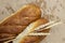 Baked bread loaves on brown paper with wheat ears and grain