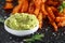 Baked butternut squash fries with sea salt, rosemary in paper cone. Pumpkin chips and quacamole dip