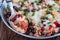 Baked casserole with black beans, pinto beans, kidney beans, rice, cheese and paprika, in a metal baking dish, horizontal, closeup