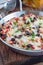 Baked casserole with black beans, pinto beans, kidney beans, rice, cheese and paprika, in a metal baking dish, vertical, closeup