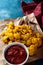 Baked cauliflower on Kraft paper with tomato sauce and chili peppers blue background