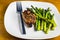 Baked chicken thigh  served with  sauteed asparagus
