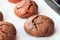 Baked cracked round chocolate cookies on a baking sheet with parchment paper just taken out of the oven. Tea snack