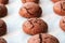 Baked cracked round chocolate cookies on a baking sheet with parchment paper just taken out of the oven. Tea snack