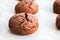 Baked cracked round chocolate cookies on a baking sheet with parchment paper just taken out of the oven. Tea snack