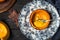 Baked creamy pumpkin soup served in a halved small pumpkin on a vintage plate on wooden background