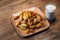 Baked crispy potatoes in a brown plate and milk in a cut glass