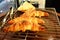 Baked croissants on grate grill with tongs in kitchen background