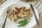 Baked diet chicken for proper nutrition on a white plate with fork and knife, home table background