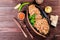 Baked dish of beef, noodles, rice, mushrooms, onions served with butter, spices and cognac in pan on wooden table.