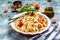 Baked feta pasta with cherry tomatoes, olive oil and herbs in a pan. Trend mixing macaroni and cheese. Food recipe background.