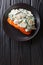 Baked Florentine salmon with creamy wine sauce, seasoned with roasted spinach and mushrooms closeup on a plate. Vertical top view