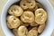 Baked fresh pretzels on white bowl on table, heart and twisted knot shapes, covered with poppy seeds salt and caraway seeds