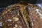 Baked loaf of artisanal whole wheat and dark rye rustic sourdough bread on a cooling rack, baked at home, photo series