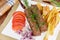 Baked lula kebab with French fries on dish close-up