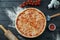 Baked margarita pizza with tomatoes and melted cheese, red sauce on a black wooden background in a composition with ingredients.