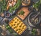 Baked mashed potato in casserole with spoon on dark rustic kitchen table background with ingredients and vintage utensils. Top