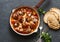 Baked meatballs with mozzarella and tomato sauce in a cast iron skillet on a dark background