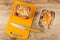 Baked muffin with raisin, knife on cutting board, muffin in foil mold on table. Top view