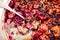 Baked oatmeal with berries and nuts, spoon in it, close-up