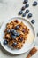 Baked oatmeal with blueberries and honey in on white plate, top view. Oatmeal fruit crumble pie