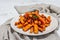 Baked organic batata fries with spices and sauce. Sweet vegetable, served portion and cutlery