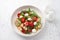 Baked panzanella, traditional Italian salad with tomatoes, mozzarella, parmesan, crispy croutons, arugula and basil on a