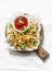 Baked parsnips french fries and homemade ketchup on cutting board - healthy vegetarian snacks on light background